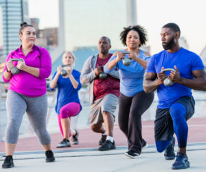 image of adults lunging with kettle bells in their hands